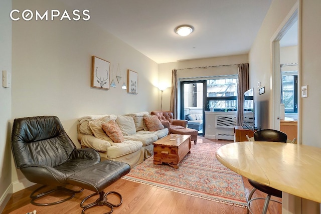 living room with baseboard heating and wood-type flooring