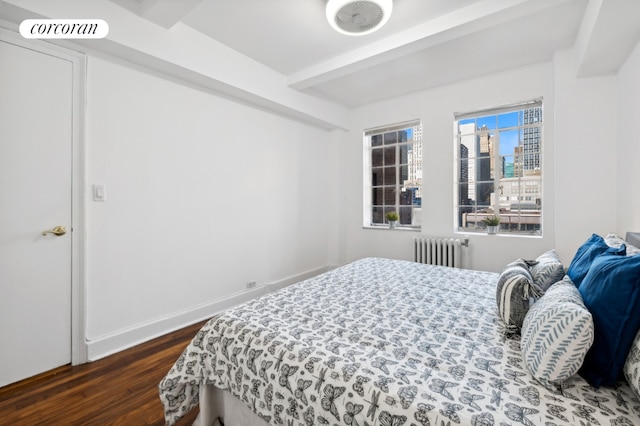 bedroom with dark hardwood / wood-style floors, radiator, and beam ceiling