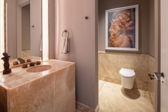 bathroom with vanity, tile walls, and toilet