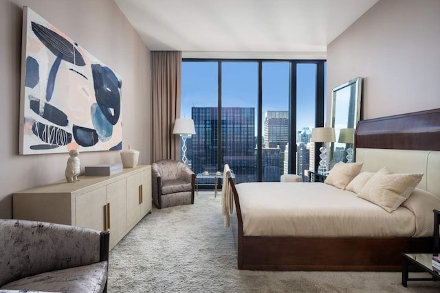 bedroom featuring light colored carpet and a wall of windows