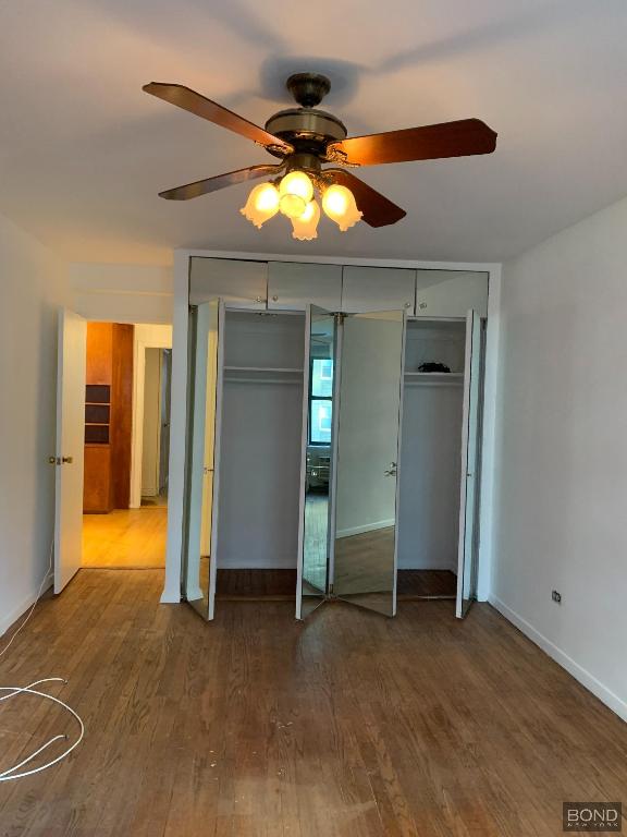 unfurnished bedroom with hardwood / wood-style floors and ceiling fan