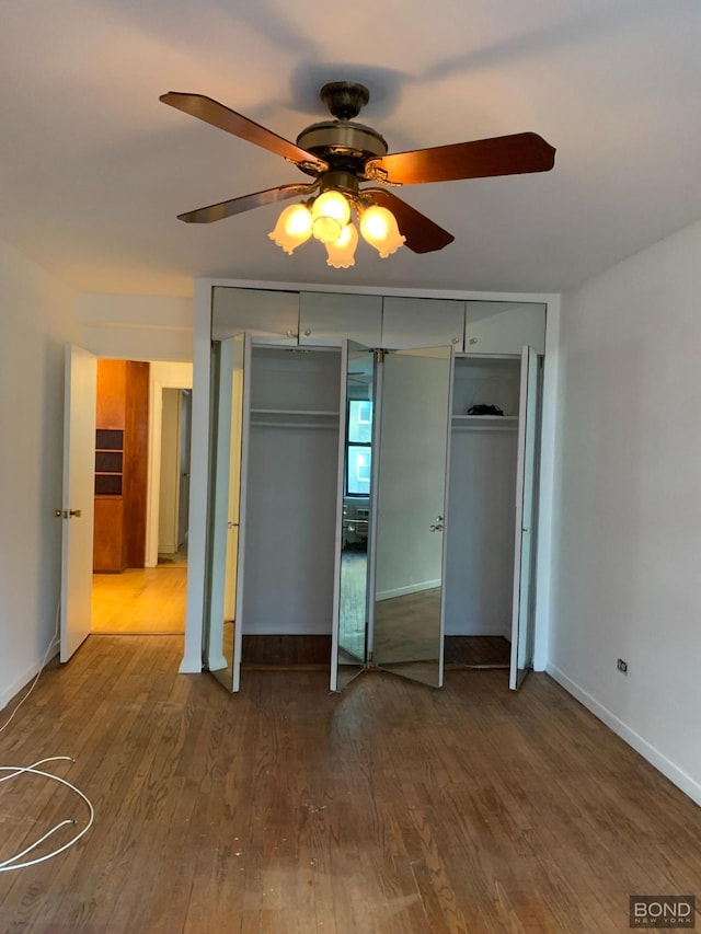 unfurnished bedroom with wood finished floors, a ceiling fan, and baseboards