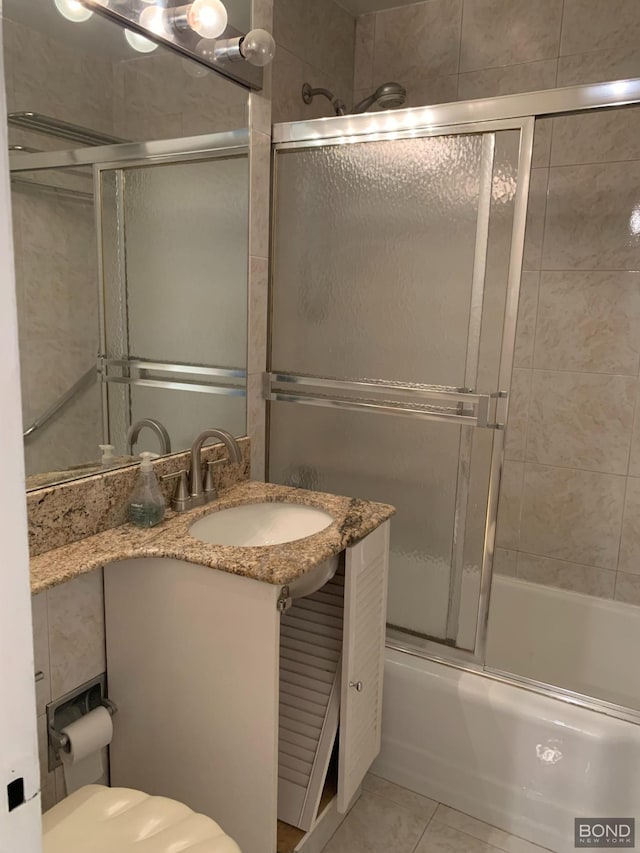 bathroom with enclosed tub / shower combo, toilet, tile patterned flooring, and vanity