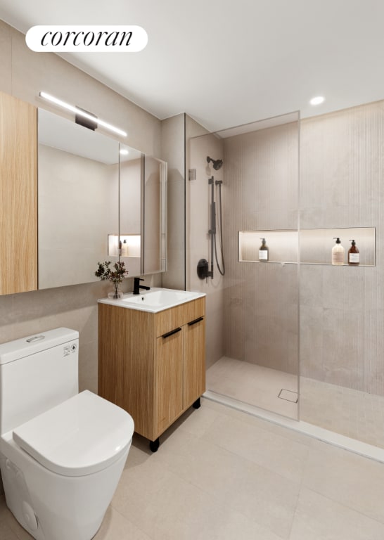 bathroom featuring toilet, vanity, and a tile shower