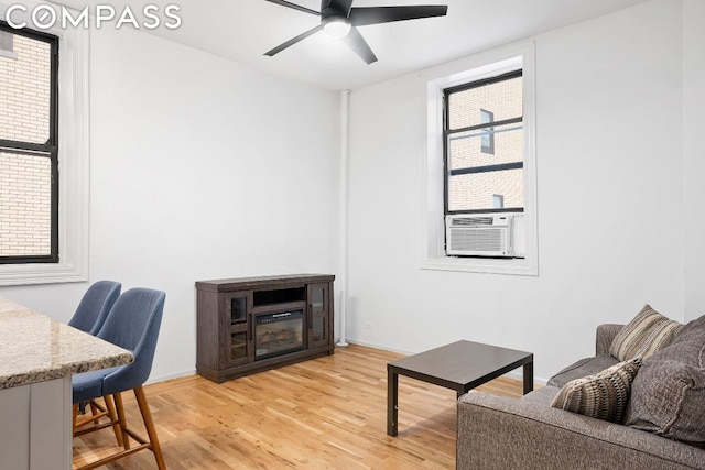 living room featuring ceiling fan, light wood-type flooring, and cooling unit