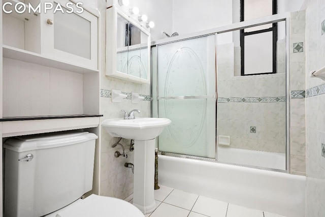 bathroom featuring toilet, tile patterned floors, and shower / bath combination with glass door