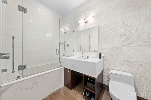 full bathroom with toilet, bath / shower combo with glass door, tile walls, vanity, and tile patterned flooring