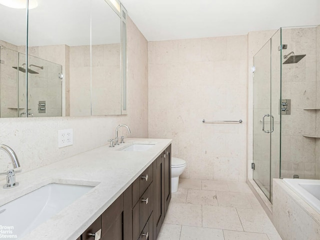 full bath with a tub to relax in, a shower stall, double vanity, and a sink