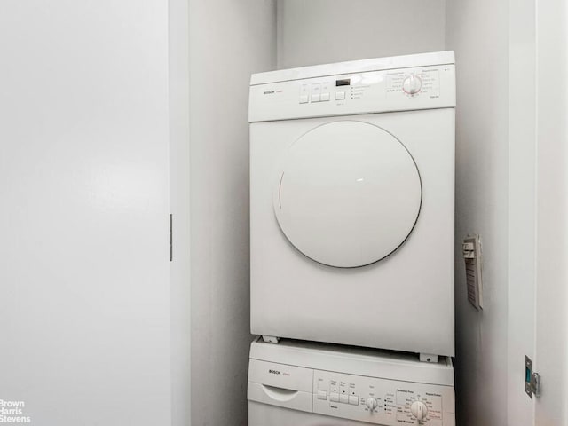 clothes washing area featuring mail area, laundry area, and stacked washer and clothes dryer