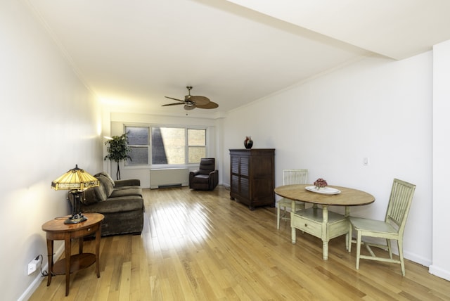 sitting room featuring ceiling fan, radiator heating unit, light hardwood / wood-style flooring, and ornamental molding