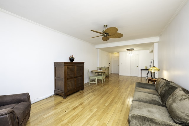 living room featuring ceiling fan, ornamental molding, and light hardwood / wood-style floors