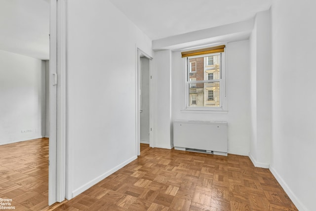 spare room featuring baseboards and radiator heating unit