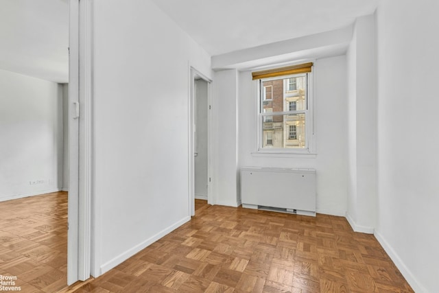 spare room featuring light parquet flooring and radiator heating unit