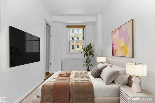 bedroom with baseboards and wood finished floors