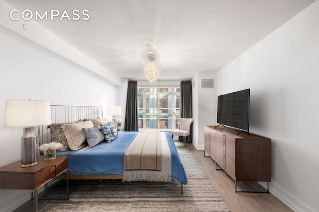 bedroom with visible vents, light wood-style flooring, and baseboards