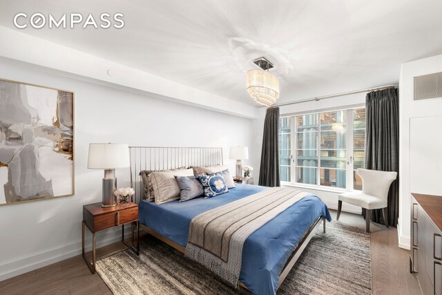 70 Charlton St Unit 11A, New York City, NY 10014 - bedroom with wood finished floors, baseboards, and a chandelier