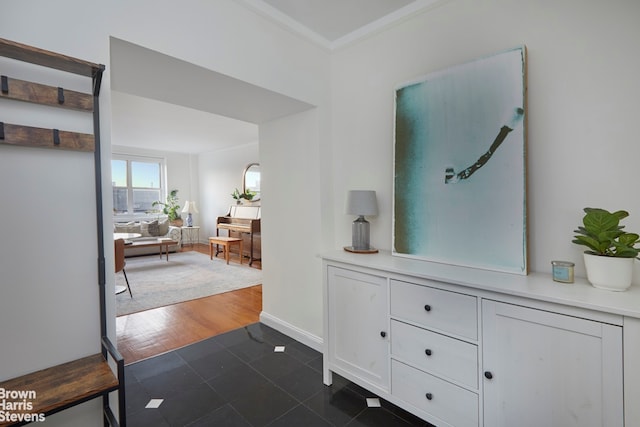 hall featuring baseboards, ornamental molding, and dark wood-type flooring