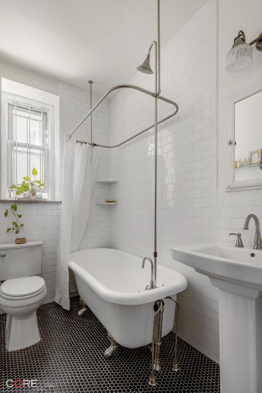 full bathroom featuring tile walls, sink, tile patterned floors, and toilet