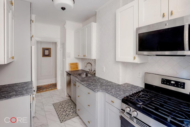 kitchen with white cabinetry, sink, backsplash, and appliances with stainless steel finishes