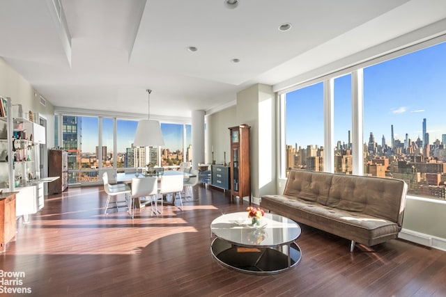 living room with a wealth of natural light, a view of city, expansive windows, and wood finished floors