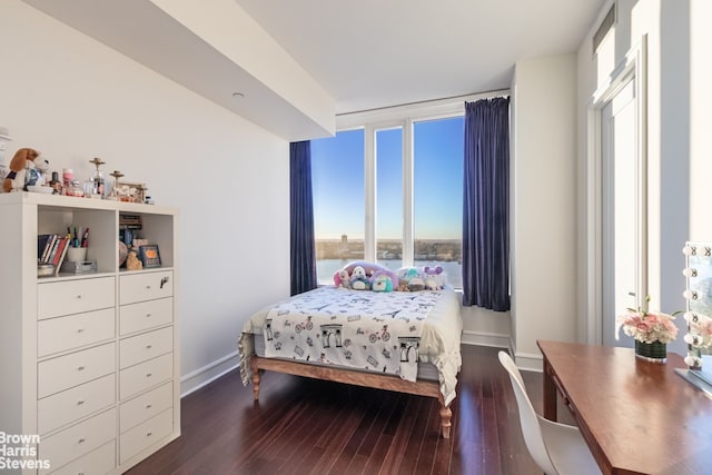 bedroom with baseboards and wood finished floors