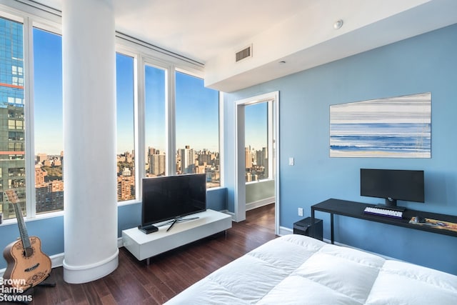 bedroom featuring wood finished floors, visible vents, and baseboards