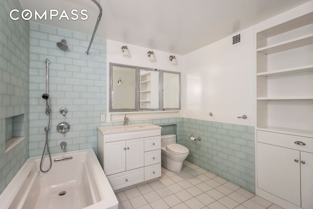 bathroom with vanity, shower / tub combination, tile walls, toilet, and tile patterned floors