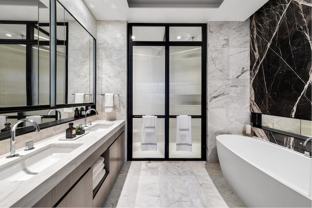 bathroom with a bathing tub, tile walls, and vanity