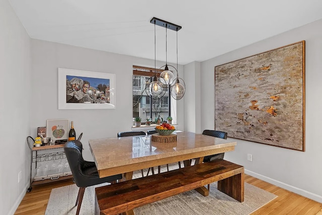 dining area with baseboards and light wood-style floors