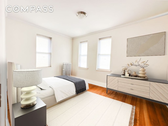 bedroom with multiple windows, wood-type flooring, ornamental molding, and radiator heating unit