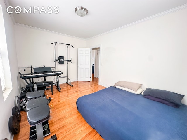 bedroom with baseboards, wood finished floors, and crown molding