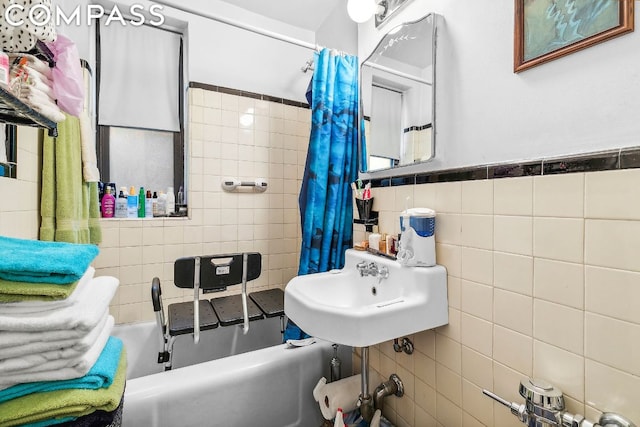 bathroom featuring tile walls, shower / tub combo, and sink