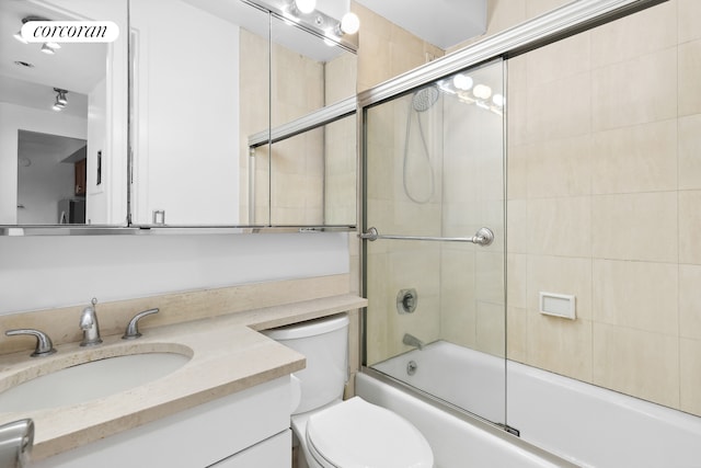 bathroom featuring vanity, toilet, visible vents, and shower / bath combination with glass door