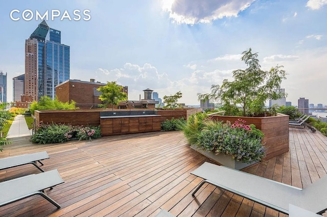 wooden deck with a city view and an outdoor kitchen