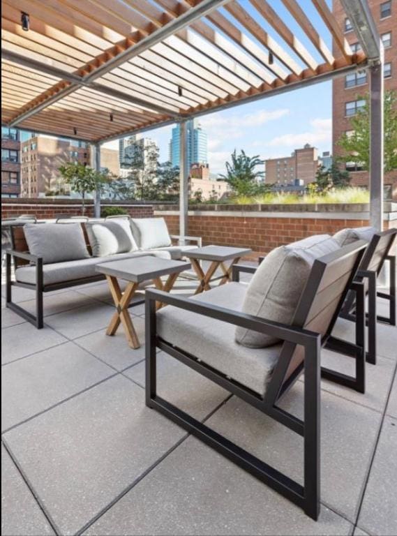 view of patio with a city view, an outdoor living space, and a pergola