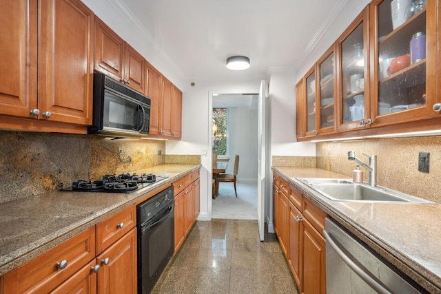 kitchen with granite finish floor, ornamental molding, a sink, black appliances, and baseboards