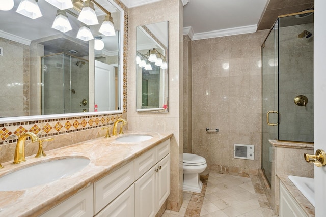 bathroom with ornamental molding, a shower stall, tile walls, toilet, and double vanity