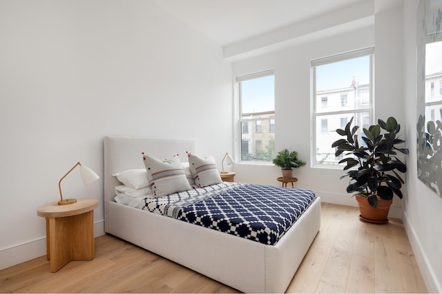 bedroom with baseboards and hardwood / wood-style floors