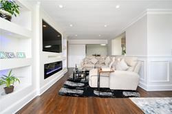 living room featuring built in shelves, dark wood-type flooring, and crown molding