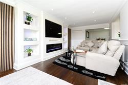 living room with built in shelves, dark hardwood / wood-style floors, and crown molding