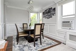 dining space with dark hardwood / wood-style flooring, crown molding, and cooling unit