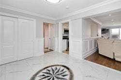 kitchen with light stone counters, a wealth of natural light, white cabinets, and crown molding