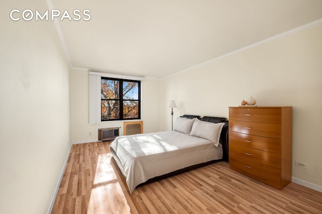 bedroom featuring light wood-type flooring, baseboards, and crown molding