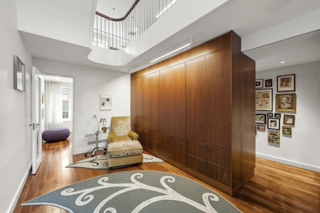 sitting room featuring hardwood / wood-style flooring and a high ceiling