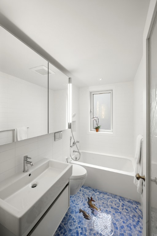 full bathroom featuring decorative backsplash, shower / bathtub combination, toilet, and tile walls