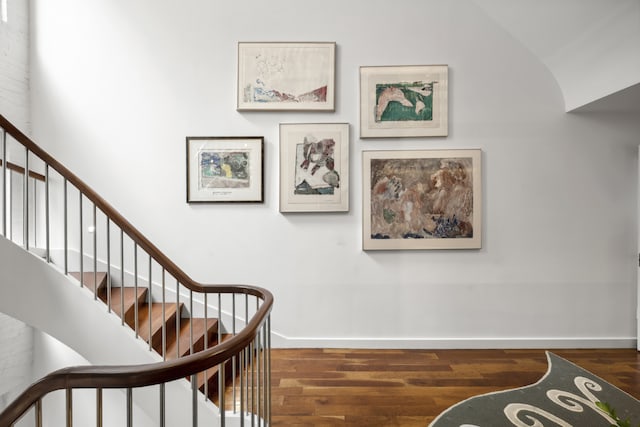 stairs with wood-type flooring and vaulted ceiling