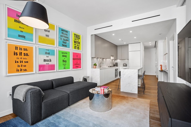 living room featuring recessed lighting, wood finished floors, and baseboards