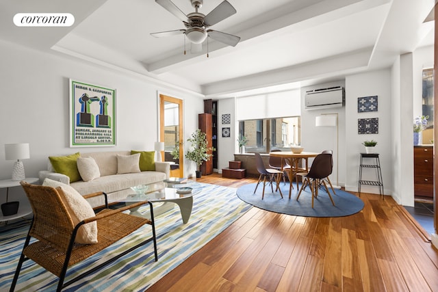 living room featuring ceiling fan, hardwood / wood-style floors, and a wall unit AC