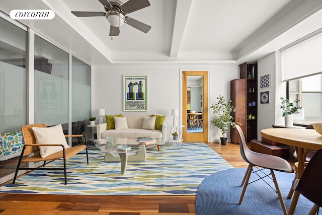 living room featuring beamed ceiling, ceiling fan, and light hardwood / wood-style floors