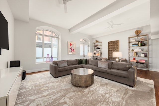 living area with ceiling fan, beamed ceiling, and light wood-style flooring